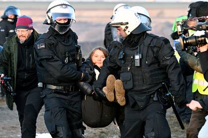 Agentes de policía llevan a la activista climática sueca Greta Thunberg lejos del borde de la mina de lignito a cielo abierto Garzweiler II durante una acción de protesta de activistas climáticos tras el desalojo de Luetzerath, Alemania, martes 17 de enero de 2023.