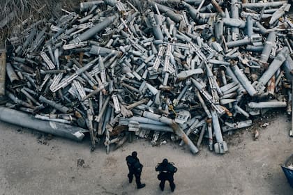 Agentes de policía observan los restos recuperados de proyectiles rusos, incluyendo algunos con munición de racimo, que golpearon Járkiv, en Járkiv, Ucrania, el 3 de diciembre de 2022