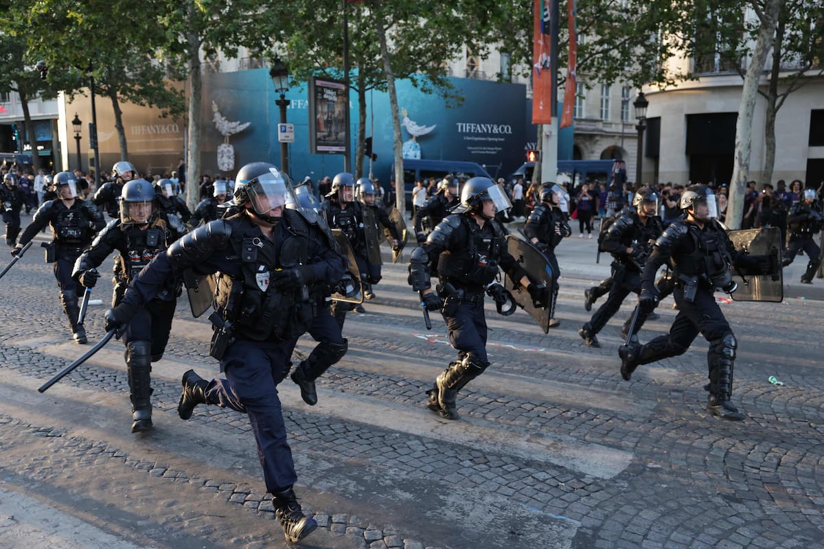 Agentes del Cuerpo Republicano de Seguridad francés corren para dispersar a los seguidores del PSG en la avenida de los Champs Elysees, durante la final de la Champions League