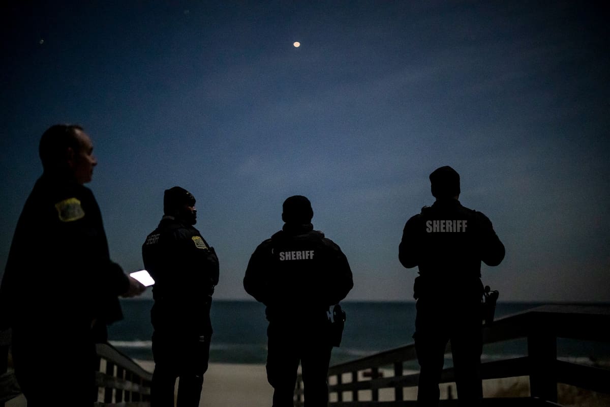 Agentes del sheriff del condado de Ocean escanean el cielo nocturno en busca de drones en el Island Beach State Park, en Lanoka Harbor, Nueva Jersey, el 13 de diciembre de 2024. (Dave Sanders/The New York Times)