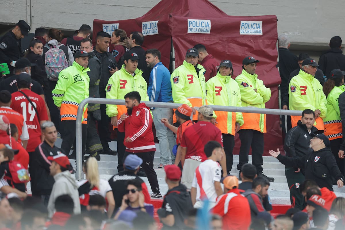 Agentes policiales y empleados de seguridad resguardan la zona donde falleció un espectador, al caer desde la tribuna durante el partido de River contra Defensa y Justicia