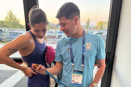 Agostina Hein y su entrenador Sebastián Montero, mirando la medalla plateada conseguida en el Mundial junior en Rumania