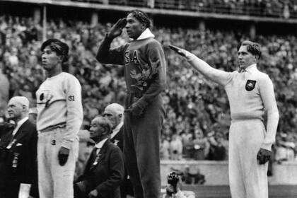 Agosto, 1936. El estadounidense Jesse Owens (centro) durante el recibimiento de la medalla de oro después de derrotar al alemán Lutz Long, en las Olimpíadas de Berlín