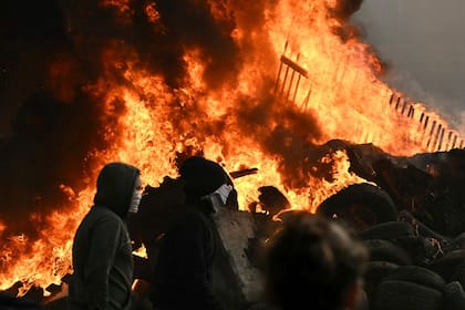 Agricultores caminan junto a una hoguera cerca del Parlamento Europeo en la Plaza de Luxemburgo, durante una protesta campesina para denunciar las reformas de la Política Agrícola Común (PAC) y acuerdos comerciales como el Mercosur, en Bruselas, el 18 de diciembre de 2025