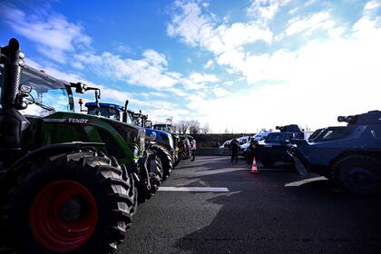 Agricultores con sus Tractores desafían a los gendarmes en una autopista en Chennevieres-les-Louvres, cerca del aeropuerto Roissy-Charles-de-Gaulle, al noroeste de París. (JULIEN DE ROSA / AFP)