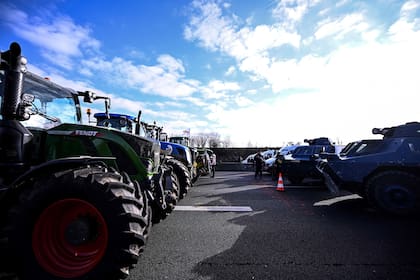 Agricultores con sus Tractores desafían a los gendarmes en una autopista en Chennevieres-les-Louvres, cerca del aeropuerto Roissy-Charles-de-Gaulle, al noroeste de París. (JULIEN DE ROSA / AFP)