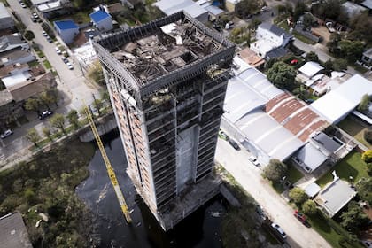 Agua acumulada en los cimientos preocupa al barrio; junto al edificio, se observa la grúa