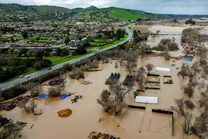 Aguas de una inundación cubren una propiedad en River Rd. en el condado Monterey, California, el viernes 13 de enero de 2023. (AP Foto/Noah Berger)