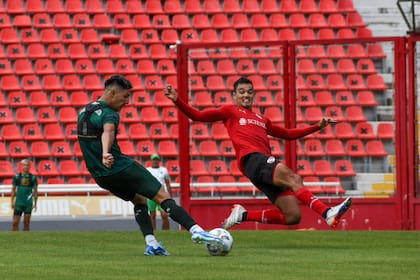 Agustín Fontana remata al arco y Felipe Aguilar se tira para tapar el remate en uno de los partidos en los que Independiente y Sarmiento disputaron este miércoles en Avellaneda