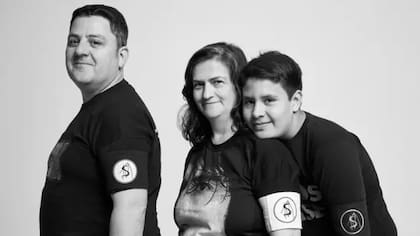 Agustín, Jorgelina y su hijo Lucas con brazaletes del álbum Say No More, de Charly García