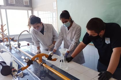 Agustín Mangüello, Victoria Wesner y Karla Buscamante, creadores de un filtro para microplásticos del lavarropas, en el laboratorio del colegio donde hicieron el desarrollo