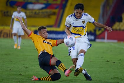 Agustin Obando y Byron Castillo disputan la pelota durante el partido entre Boca y Barcelona de Ecuador