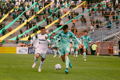 Agustín Palavecino lleva la pelota ante la marca de Ulises Gimenez