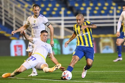 Agustín Sandez va al piso y trata de recuperar la pelota ante Zabala, en el partido que Boca le ganó a Rosario Central 2-1