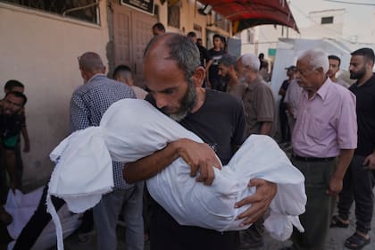 Ahmed Al-Hajj carga el cuerpo de su hija, Dana Al-Hajj, quien murió en un ataque aéreo israelí en la Franja de Gaza, en el Hospital Al-Aqsa, en Deir al-Balah, el martes 19 de agosto de 2025