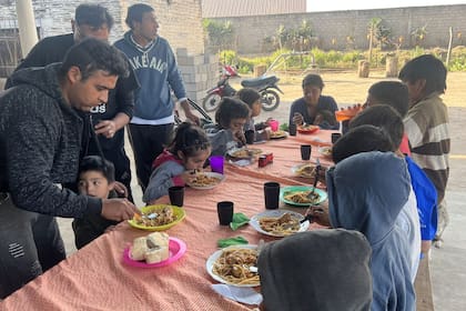 Al final de la mesa, Diego, su hermana Analía y su mamá comen un guiso de fideo con pollo