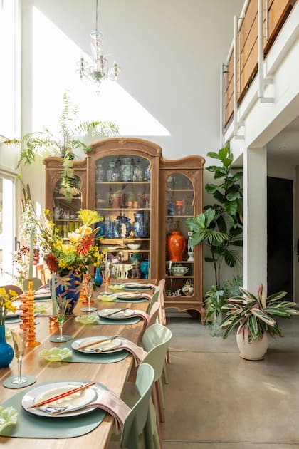 Al fondo, gran aparador del Mercado de Pulgas con el lustre oscuro lavado en un ambiente alto, blanco, con un sencillo piso de cemento alisado y muchas plantas: frescura asegurada