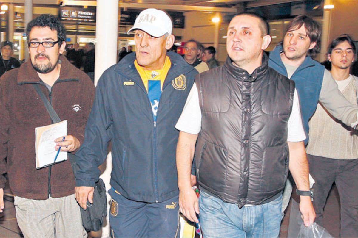 Al frente, con campera negra sin mangas, Pillín Bracamonte, de la barra de Central, en su regreso a Ezeiza