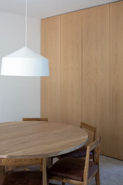 Al ingreso, una mesa de comedor circular con sillas de petiribí y cuero.