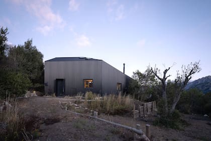 Al llegar, la casa ofrece su cara más cerrada. Una vez dentro, los ambientes principales revelarán las majestuosas vistas hacia el lago y el propio terreno.