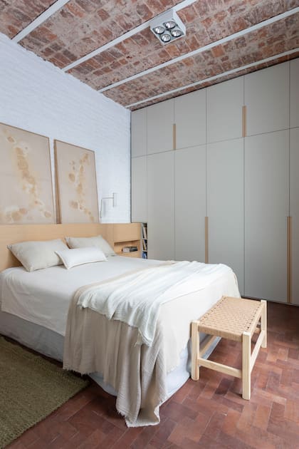 Al pie, banco armado y encordado por la dueña de casa. Ropa de cama (Lote Propio). Obras con tintes naturales de Lola Pérez Studio. El piso es el original de caldén: solo fue pulido y encerado