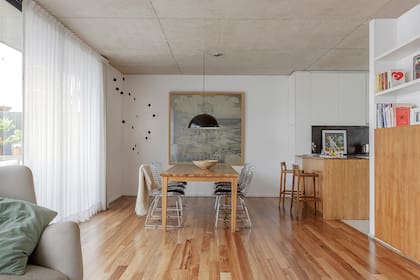 Al proyecto original sumaron un volumen que de un lado es espacio de guardado, en el frente es biblioteca, y en la cocina contiene la heladera. En la barra de incienso, banquetas (Net Muebles).