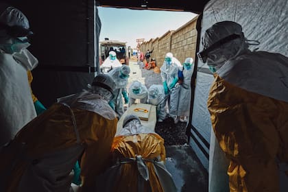 Al salir de la morgue, equipos de la Cruz Roja están presentes para desinfectar el ataúd antes de llevarlo al cementeri