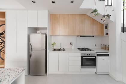 Alacena de madera enchapada en kiri lustrado natural, bajomesada de madera laqueada blanco mate (Vita Arquitectura). Mesada de Silestone 'Blanco Zeus', alzada de porcelanato Portobello de 30x60 'Glacier White' rectificado mate.