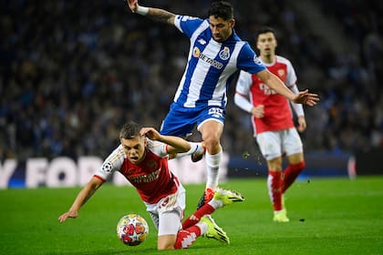 Alan Varela salta sobre el delantero Leandro Trossard en la victoria de Porto ante Arsenal