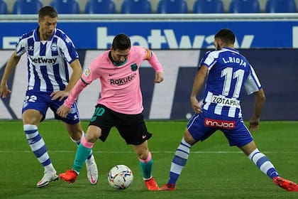 Messi maniobra entre dos jugadores de Alavés
