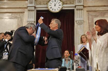 Alberto Fernández asume como Presidente de la Nación, Mauricio Macri le coloca la Banda Presidencial y le entrega el Bastón, los acompaña la vicepresidenta Cristina Kirchner