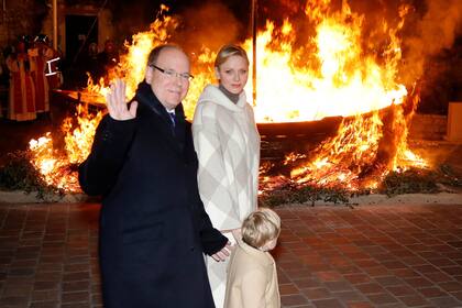Alberto y Charlene, con su hijo Jacques posan junto a una barca ardiendo