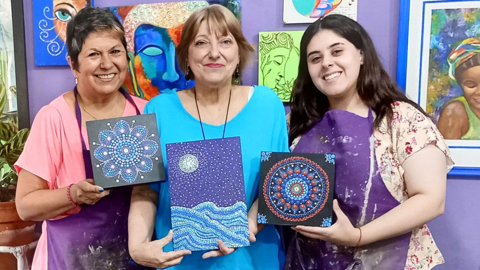 Alejandra, en el centro, en una clase de pintura con su profesora y una compañera.