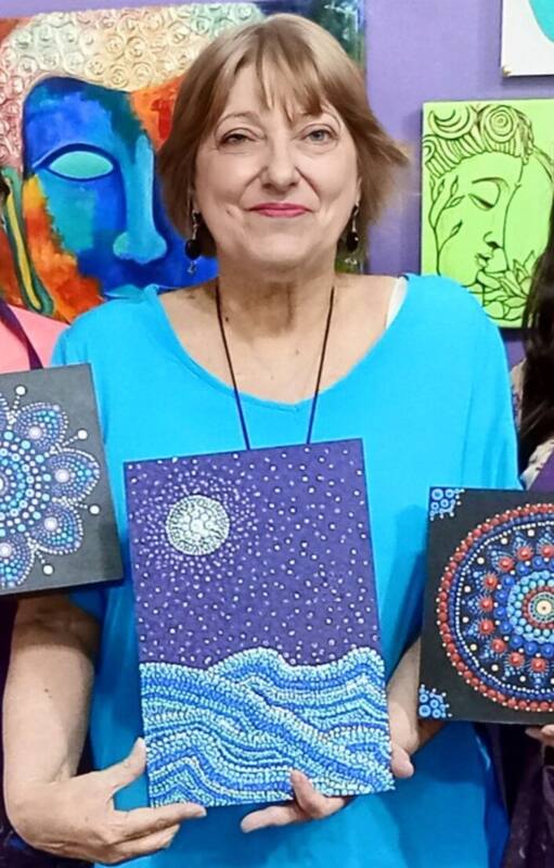 Alejandra, en el centro, en una clase de pintura con su profesora y una compañera.