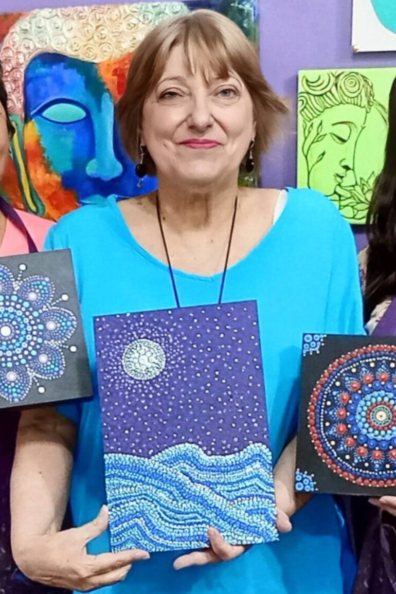 Alejandra, en el centro, en una clase de pintura con su profesora y una compañera.
