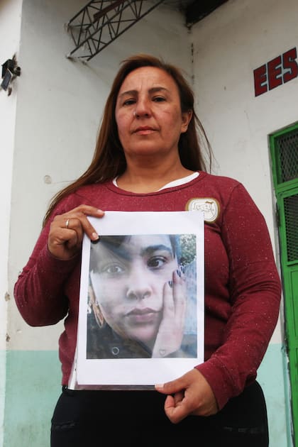 Alejandra, madre de Roxana Paola Villalba, una joven desaparecida desde 2018, posa con la foto de su hija en la puerta de la escuela en la que Roxana debería ir a votar este domingo
