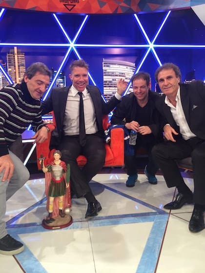 Alejandro Fantino, Jorge Higuain y Oscar Ruggeri posan junto a la imagen de San Expedito en Animales Sueltos.