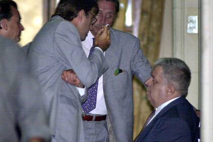 Alejandro Taranto, de pie, habla con testigos en el Juzgado de Dolores, el 28 de febrero de 2001