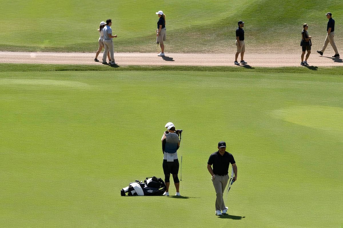 Alejandro Tosti se va del green, su caddie ya dejó la bolsa y se saca la pechera: fin de la historia