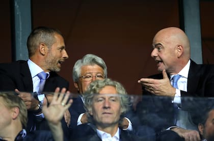 Aleksander Ceferin, presidente de la UEFA, charla con Gianni Infantino, de la FIFA; la UEFA ha sido la principal opositora al plan de privatización