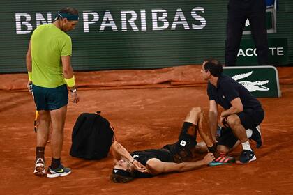Alexander Zverev es asistido, mientras Rafael Nadal observa. Un final que nadie quería en Roland Garros