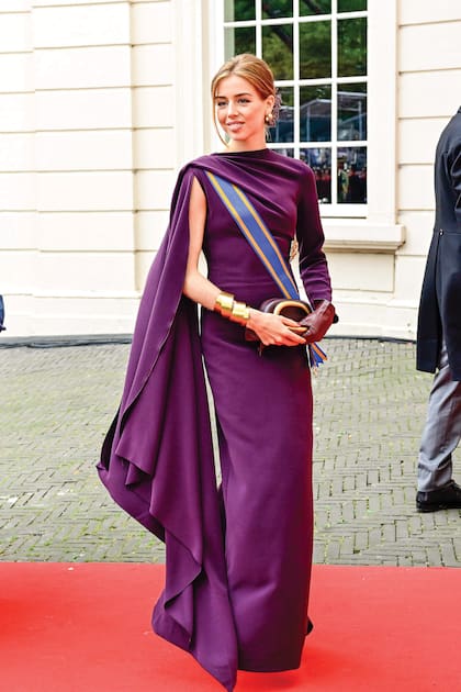 Alexia eligió un vestido de Solace London, de corte asimétrico con una sola manga y capa. Lo complementó aros y maxibrazalete dorados, guantes y clutch de Zara. A diferencia de sus hermanos, no llevó tocado: optó por un recogido adornado con un detalle floral del mismo tono de su traje