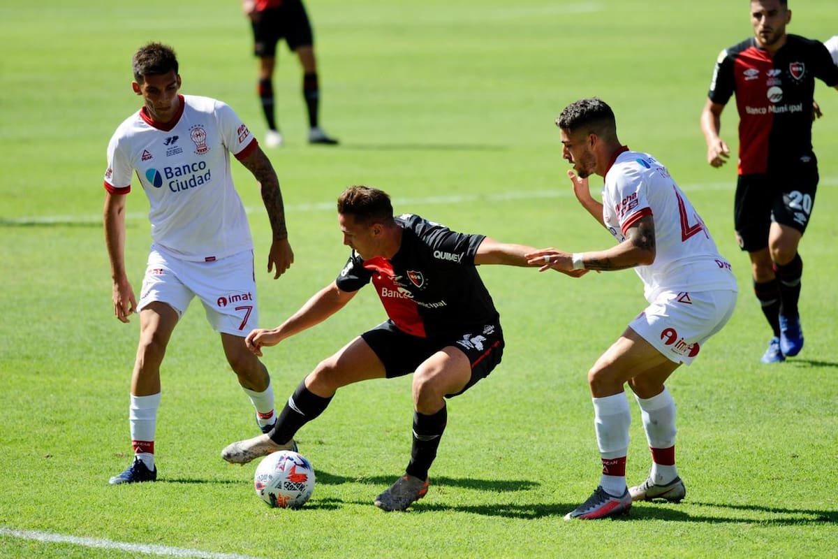 Alexis Rodríguez intenta dominar la pelota ante las marcas de Erquiaga y Garro (7); a Newell's se le escapó el triunfo sobre el final
