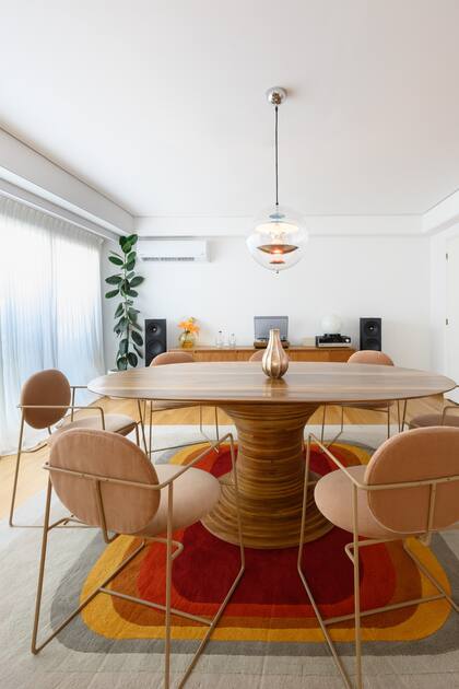 Alfombra de lana patagónica hecha a pedido (JT. Pfeiffer). Mesa (BoConcept) con obra del orfebre Emiliano Céliz. Sillas 'Almendra' (Bull). Lámpara de techo 'VP Globe' del diseñador danés Verner Panton.