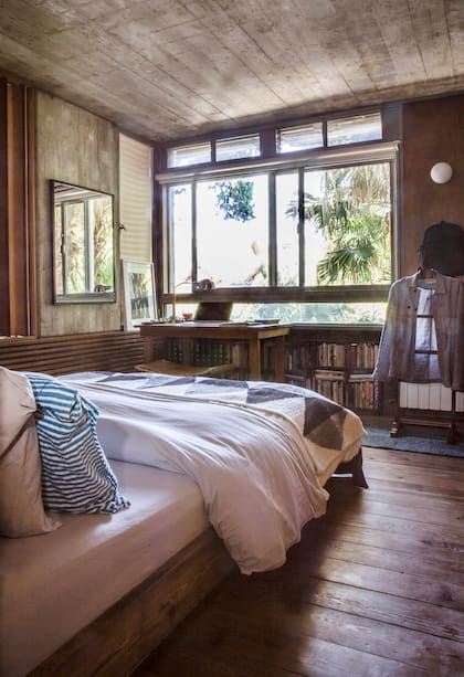 Alfombra de Seara a modo de pie de cama. Colgada en un perchero junto a la entrada del baño, chaqueta de Candioti hecha a partir de géneros de Ágave, una novedad de esta temporada.