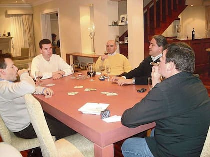 Alfredo Lijo (en la cabecera, de frente) junto a su hermano, el juez Ariel Lijo (camisa negra, de perfil), quien fuma un habano mientras juegan al truco