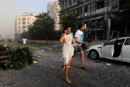 Algunas personas huyen de la zona de la explosión en el puerto de Beirut, en el Líbano