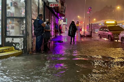 Algunas personas tratan de seguir su camino en el Bronx, pese a las constantes lluvias.