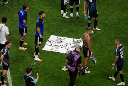 Algunos jugadores rodeando la bandera con el mensaje: "Las Malvinas son argentinas"