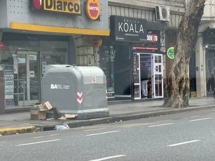 Algunos restos de cartón y cajas en los alrededores de un contenedor de basura sobre la avenida Santa Fe y Bonpland